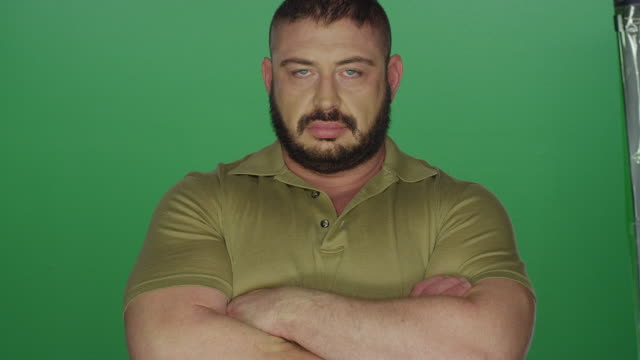 muskulöser-Mann-posiert-mit-seinen-Armen-gekreuzt,-auf-einem-green-Screen-Studio-Hintergrund