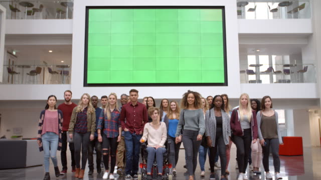 Große-Gruppe-von-Studenten-gehen-in-der-Universität-Atrium-zu-Kamera