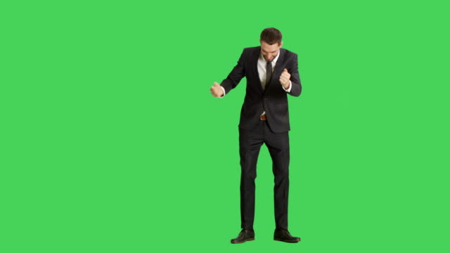 Long-Shot-of-a-Handsome-Smiling-Businessman-Dancing,-Making-Finger-Guns-Gesture-and-Having-Fun.-Background-is-Green-Screen.