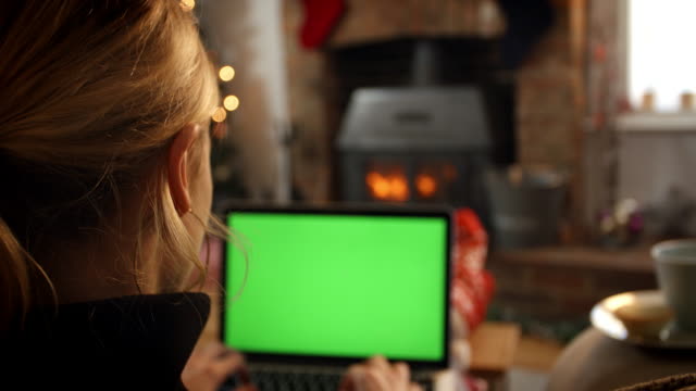 Mujer-en-línea-con-el-ordenador-portátil-en-habitación-listo-para-Navidad