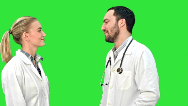 Junger-Arzt-Witz-auf-seinem-Kollegen-nicht-geben-fünf-auf-einem-Green-Screen,-Chroma-Key