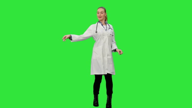 Smiling-young-woman-in-lab-coat-making-funny-dance-on-a-Green-Screen,-Chroma-Key