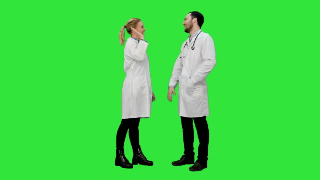 Médico-hombre-divertido-bromeando-sobre-mujer-enfermera-dará-una-falsa-Hola-cinco-en-una-pantalla-verde-Chroma-Key