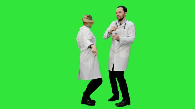 Two-funny-medical-doctors-with-funny-energy-dance-on-a-Green-Screen,-Chroma-Key
