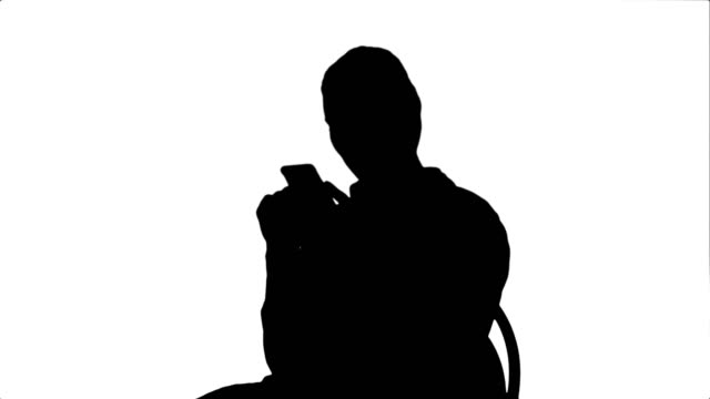 Silhouette-Young-woman-surgeon-doctor-reading-sms-on-cell-phone