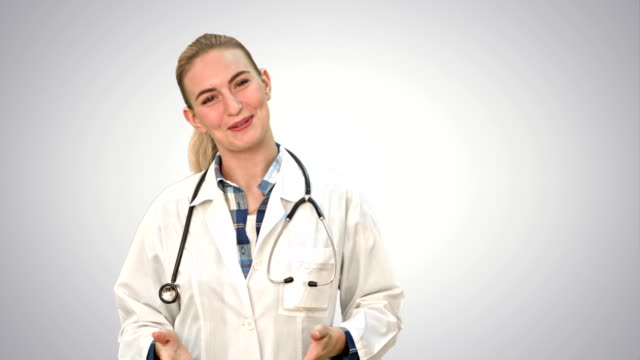 Smiling-beautiful-woman-in-lab-coat-talking-to-the-camera-on-white-background