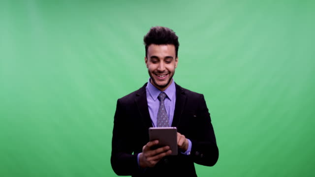 Fröhliche-Geschäftsmann-halten-Tablet-Computer-über-Chroma-Key-plaudernd-Online-Green-Screen-glücklich-lächelnde-junge-Latin-Business-Mann