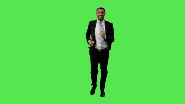 Happy-businessman-in-a-suit-is-running-on-a-mock-up-green-screen-in-the-background.