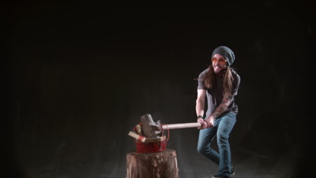 Man-smashing-Christmas-gift-with-hammer-in-slow-motion