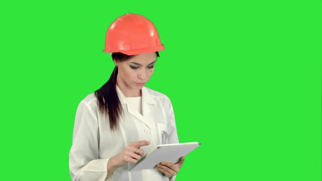 Ingenieurin-im-Helm-mit-Tablet-Computer-auf-einem-Green-Screen,-Chroma-Key