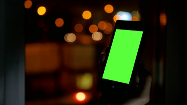 Mujer-buscando-a-smartphone-con-pantalla-verde