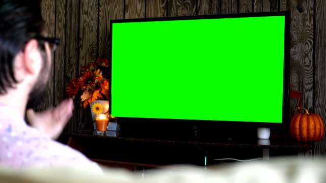 Angry-millennial-male-displeased-at-generic-sports-game-on-green-screen-TV