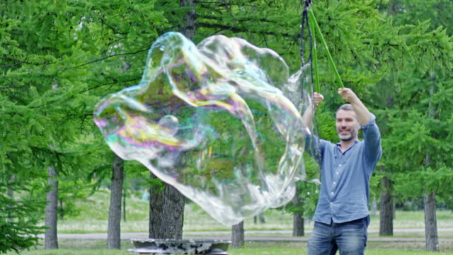 Joyous-Man-Blowing-Soap-Bubbles-with-Tri-Strings-Wand