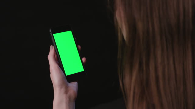 Mujer-está-sosteniendo-el-teléfono-con-toque-de-pantalla-verde