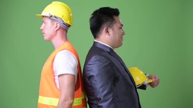 Trabajador-de-la-construcción-del-hombre-escandinavo-y-hombre-de-negocios-asiático-trabajando-juntos
