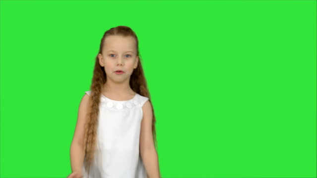 Cute-little-girl-singing-a-song-and-dancing-on-a-Green-Screen,-Chroma-Key
