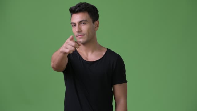 Young-handsome-Hispanic-man-against-green-background