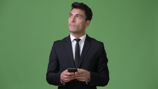Junge-hübsche-Hispanic-Geschäftsmann-vor-grünem-Hintergrund