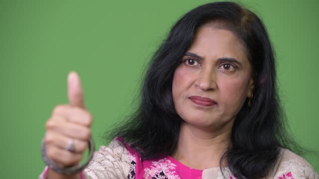 Close-up-shot-of-mature-beautiful-Indian-woman-giving-thumbs-up