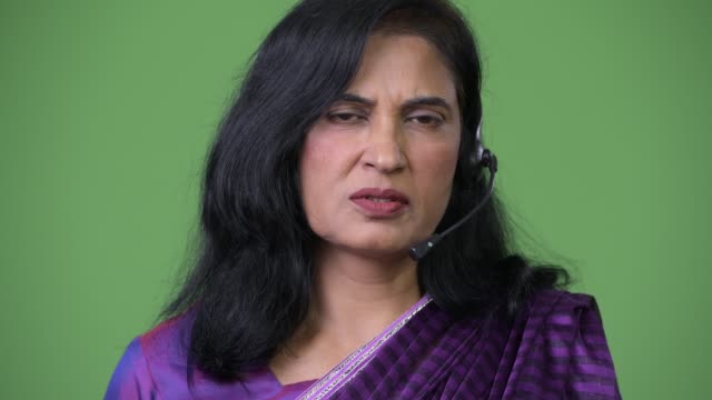 Close-up-shot-of-mature-beautiful-Indian-woman-as-call-center-representative-talking-on-headset