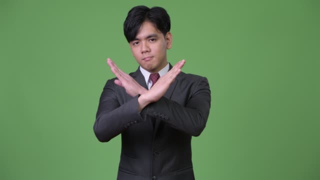 Joven-empresario-asiático-guapo-gesticular-para-detener