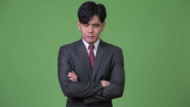 Junge-wütend-asiatischen-Geschäftsmann-mit-geschlossenen-Augen-und-Arme-verschränkt