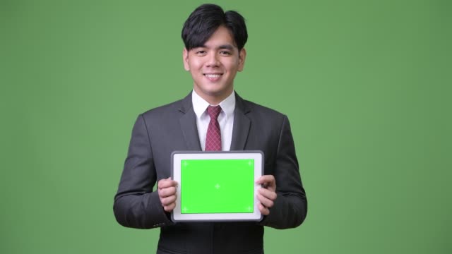 Junge-hübsche-asiatische-Geschäftsmann-mit-digital-Tablette