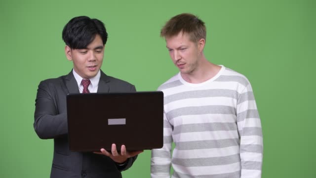 Young-handsome-Asian-businessman-and-young-Scandinavian-businessman-working-together