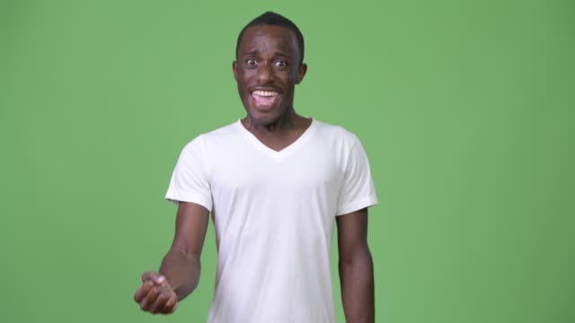 Junge-afrikanische-glücklich-mit-grünen-Hintergrund-erhobener-Faust