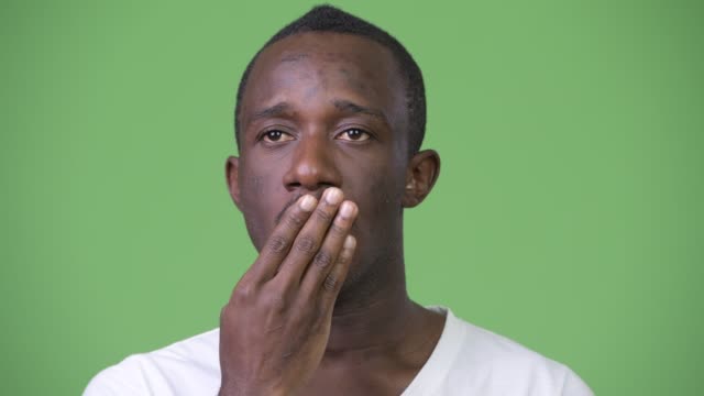 Junge-afrikanische-Mann-schockiert-und-schuldig-vor-grünem-Hintergrund
