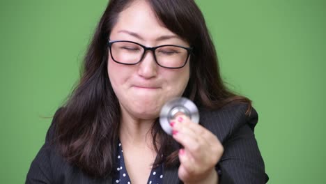 Mature-beautiful-Asian-businesswoman-playing-with-fidget-spinner