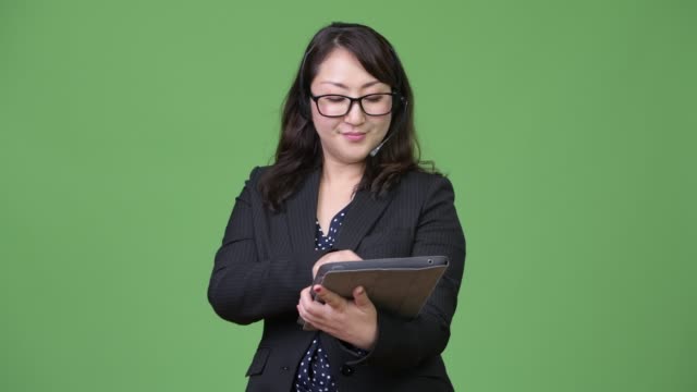 Reife-schöne-asiatische-geschäftsfrau-arbeitet-als-Call-Center-Vertreter-und-mit-digital-Tablette