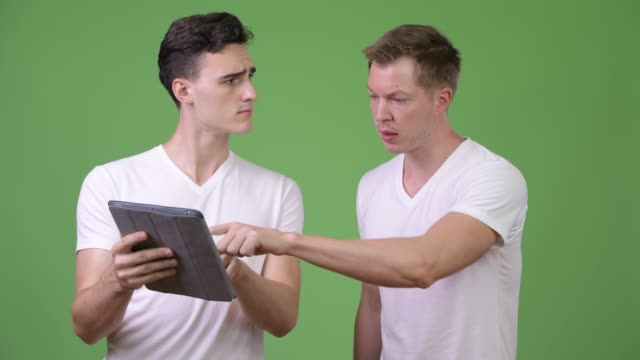 Two-young-handsome-men-using-digital-tablet-together