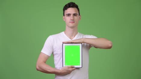 Schönen-jungen-Mann-zeigt-digital-Tablette