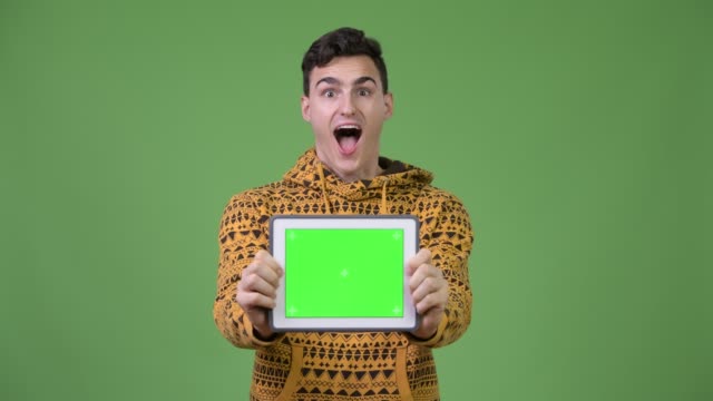 Hombre-joven-guapo-mostrando-tableta-digital-y-mirando-sorprendido
