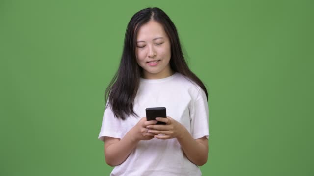 Young-Asian-woman-thinking-while-using-phone