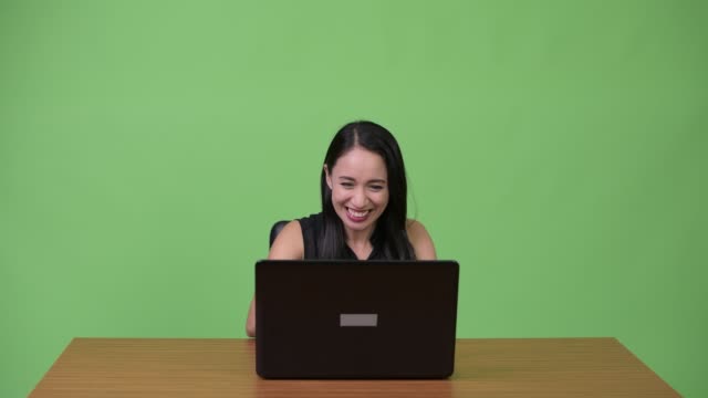 Young-Asian-businesswoman-using-laptop-with-young-man-getting-angry