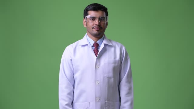 Young-happy-Persian-man-doctor-wearing-protective-glasses