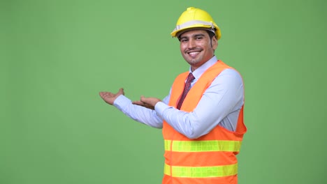 Trabajador-de-la-construcción-del-joven-persa-guapo-mostrando-algo