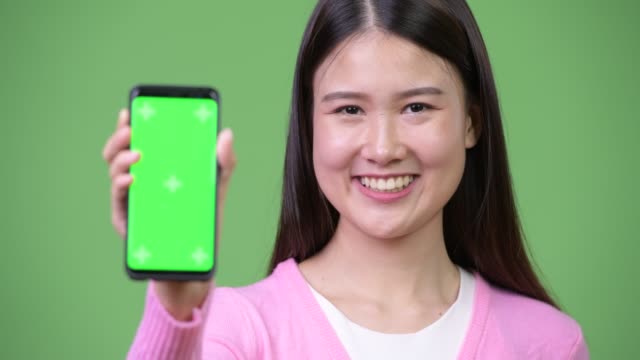 Young-beautiful-Asian-woman-showing-phone
