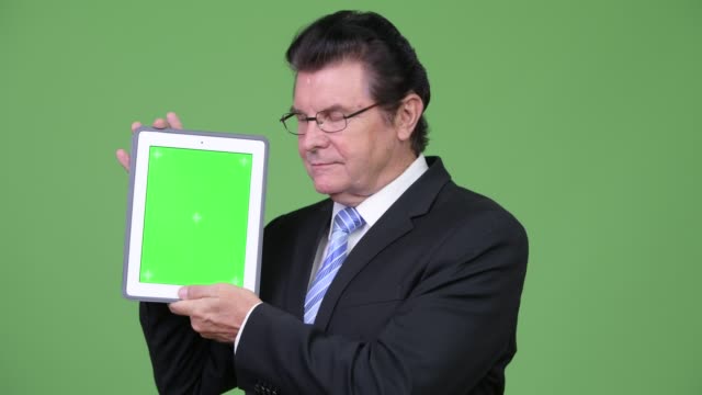 Tableta-digital-de-Senior-empresario-guapo-mostrando