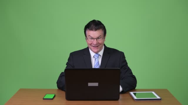 Senior-handsome-businessman-using-laptop-and-getting-good-news