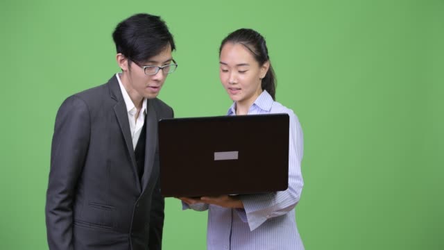 Young-Asian-business-couple-using-laptop-together