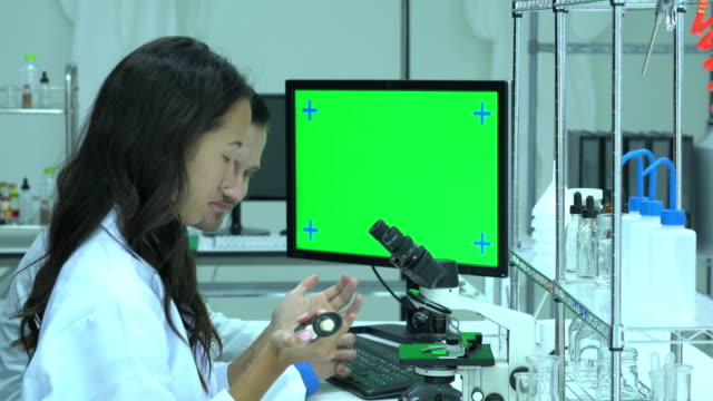 Wissenschaftler-arbeiten-in-modernen-Labors-oder-medizinisches-Zentrum.-Hintergrund-grüne-Bildschirm.-Begriff-von-Wissenschaft,-Entwicklung-und-Labor-Industrie-testen.