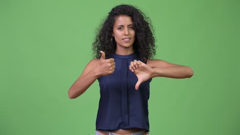 Young-beautiful-Hispanic-businesswoman-choosing-between-thumbs-up-and-thumbs-down