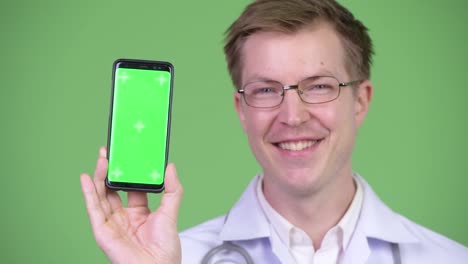 Feliz-hombre-Doctor-mostrando-croma-clave-pantalla-verde-móvil