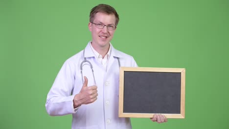 Man-Doctor-Holding-Empty-Blackboard-With-Copyspace