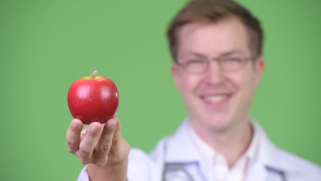 Retrato-de-joven-hombre-Doctor-Holding-rojo-manzana