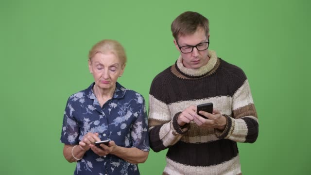 Happy-grandmother-and-grandson-using-phone-and-thinking-together