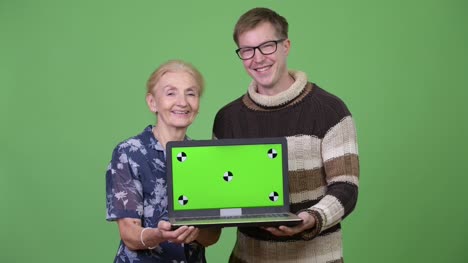 Glückliche-Großmutter-und-Enkel-zeigt-Laptop-zusammen